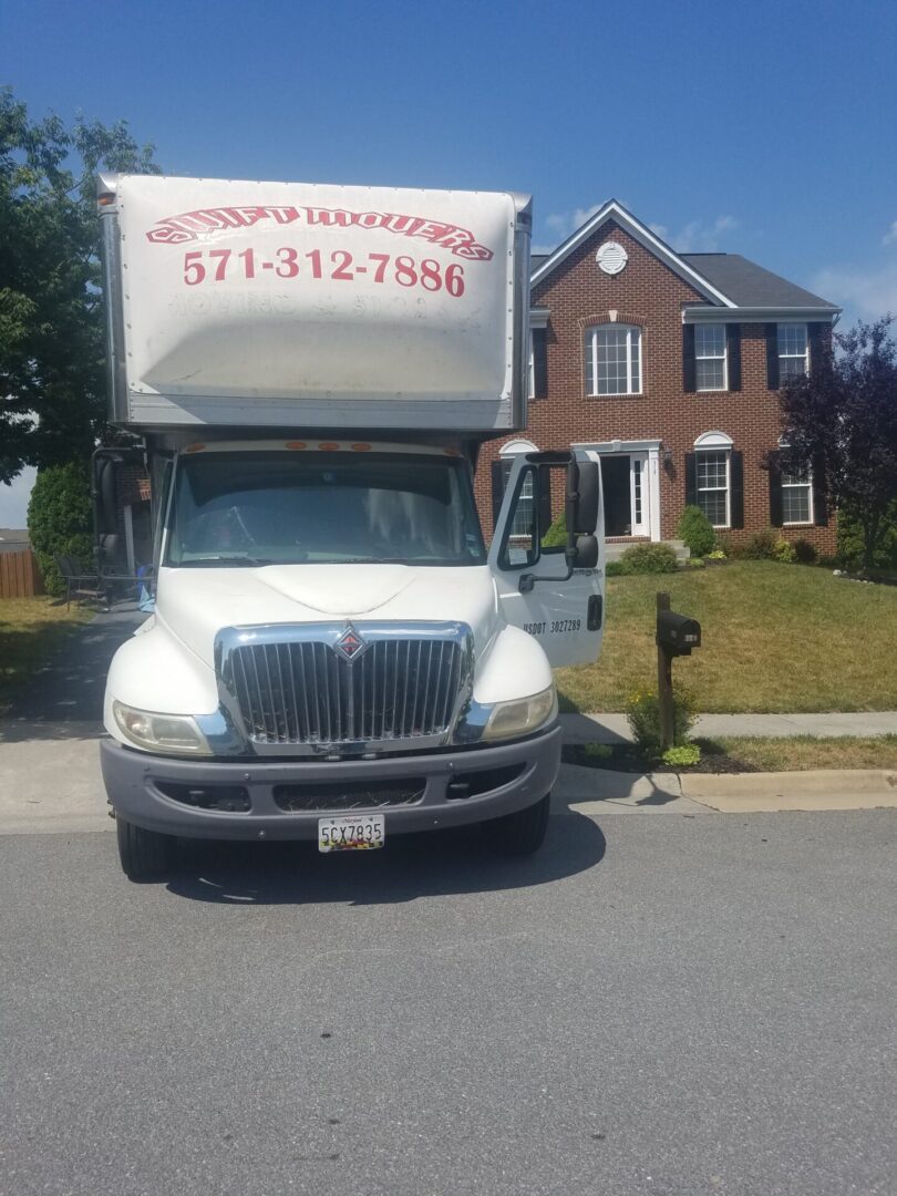 A moving truck parked in front of a house.