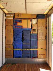 A storage unit filled with boxes and clothes.