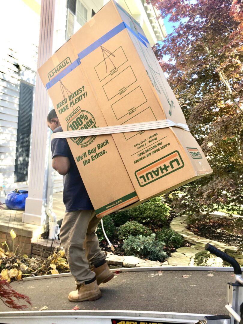 A man carrying boxes on his back while walking.