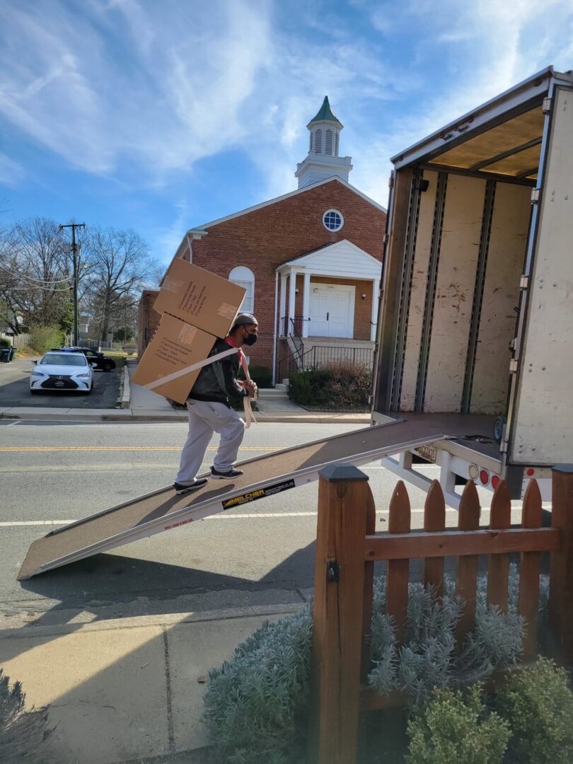 A man carrying a large piece of wood on top of a ramp.